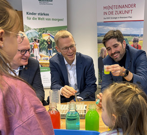Bildungsminister Sven Teuber (rechts) und Stiftungsvorstand Dr. Tobias Ernst experimentieren zusammen mit Kindern in der Kita Trierweiler.