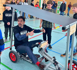 Bildungsminister Sven Teuber in einem Solarauto, gebaut von Schülerinnen und Schüler der Realschule plus.