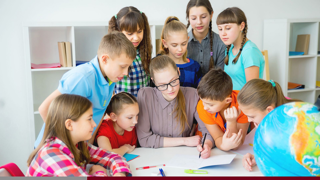 Zu sehen ist eine Gruppe von Schülerinnen und Schülern mit einer Lehrerin. 