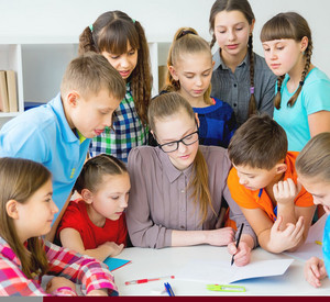 Zu sehen ist eine Gruppe von Schülerinnen und Schülern mit einer Lehrerin. 