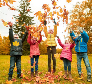 Kinder spielen mit buntem Herbstlaub