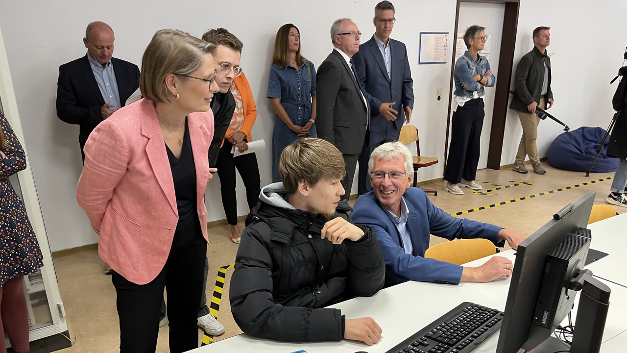 Zu sehen sind Bildungsministerin Dr. Stefanie Hubig und Dr. Eckart Lensch, Schuldezernent der Stadt Mainz mit einem Schüler der Berufsbildenden Schule BBS Mainz 3 im Gespräch. 